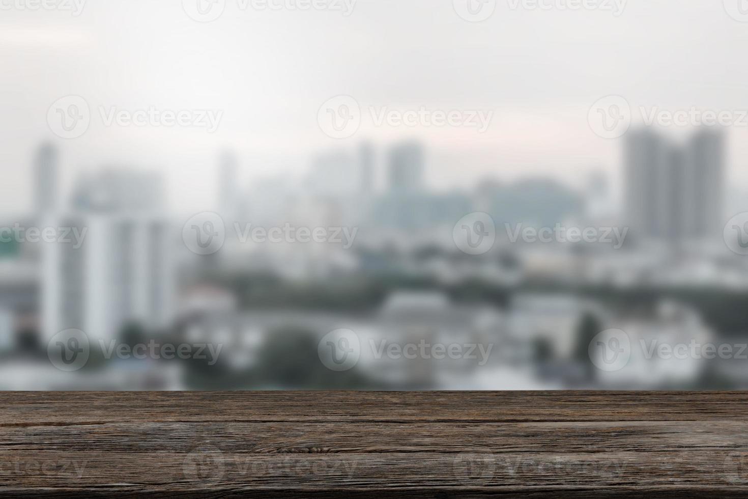 leeg houten tafel top met visie van stad of houten bureau met stadsgezicht met vervagen achtergrond, kopiëren ruimte voor uw tekst foto