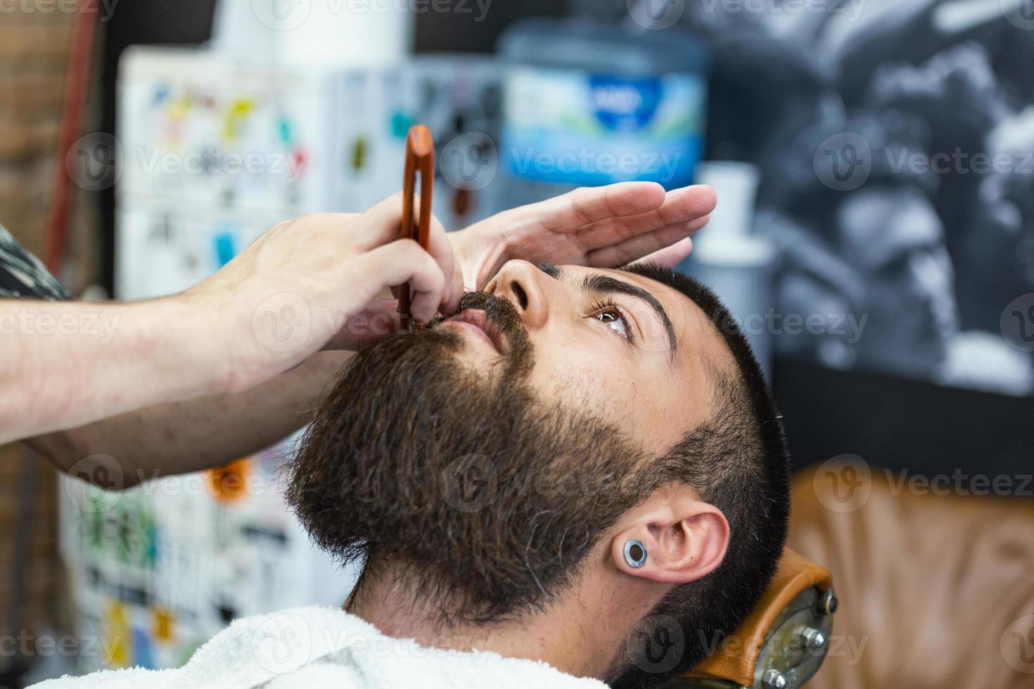 baard styling en snee. dichtbij omhoog bijgesneden foto van een styling van een baard. zo modieus en stijlvol. reclame en kapper winkel concept. scheermes in handen van specialist kapper