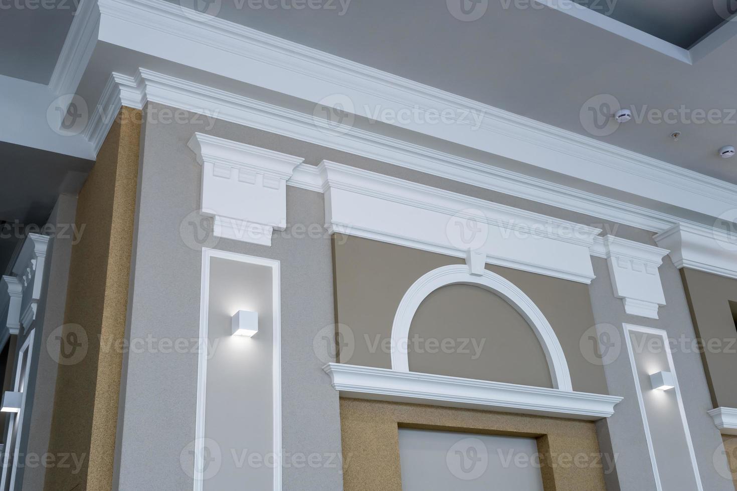 detail van hoekplafond met ingewikkelde kroonlijst op kolom met spotlicht foto