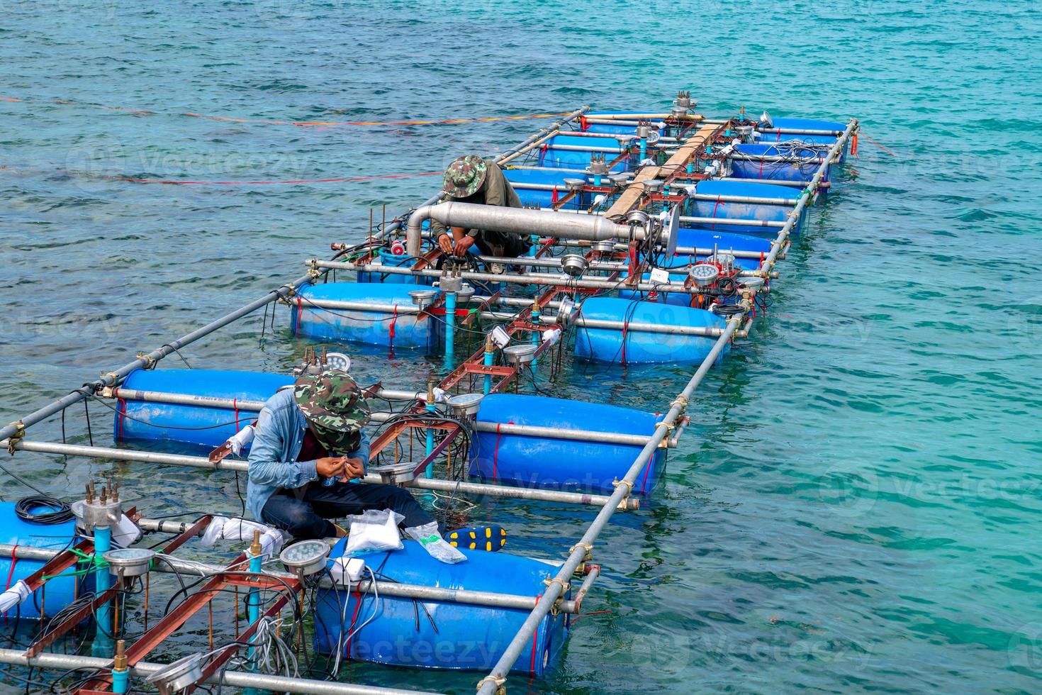 arbeiders vestigen en installeren de fonteinmachine van de waterleiding op het oppervlak van de zee. foto