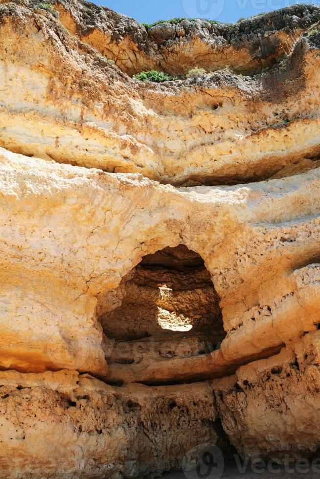 grot in geërodeerd zandsteen rots in de buurt Albufeira foto