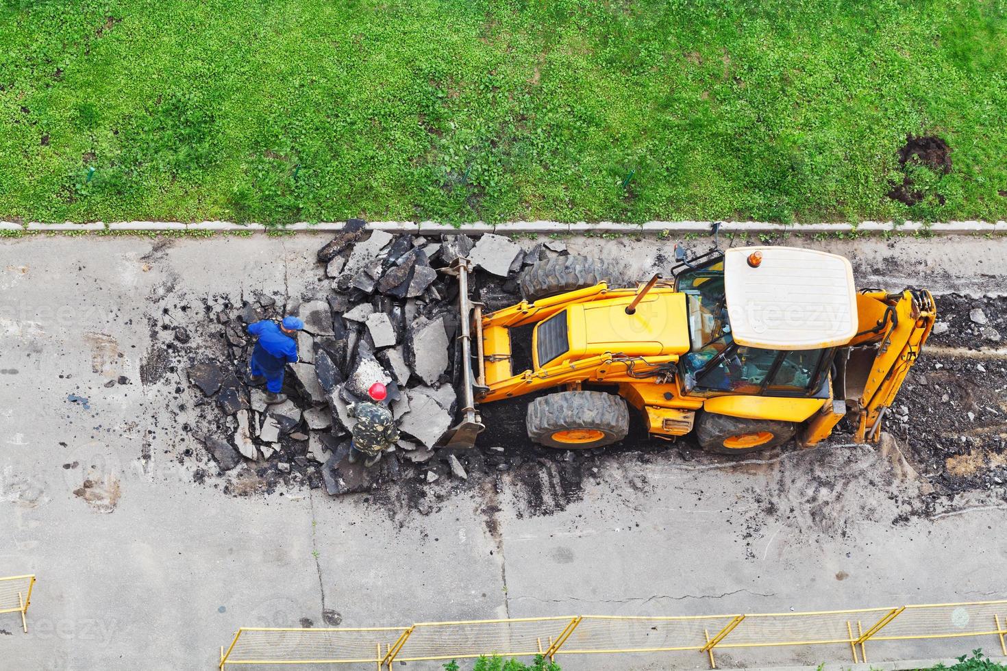 arbeiders en trekker verwijderen asfalt foto