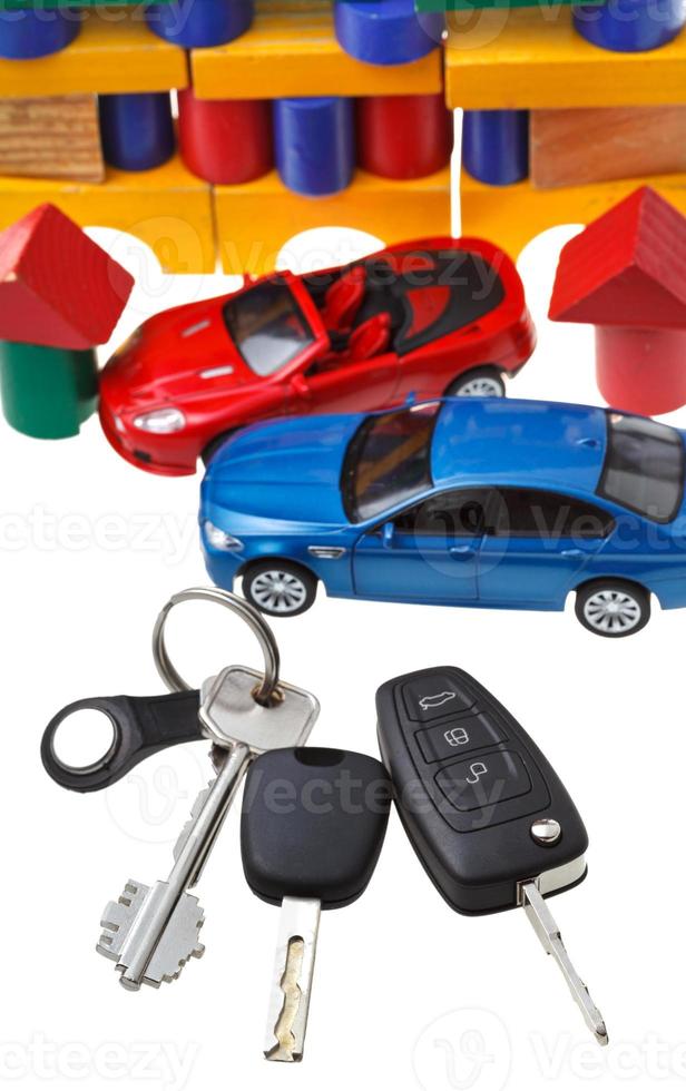 deur, voertuig sleutels, twee auto modellen en blok huis foto