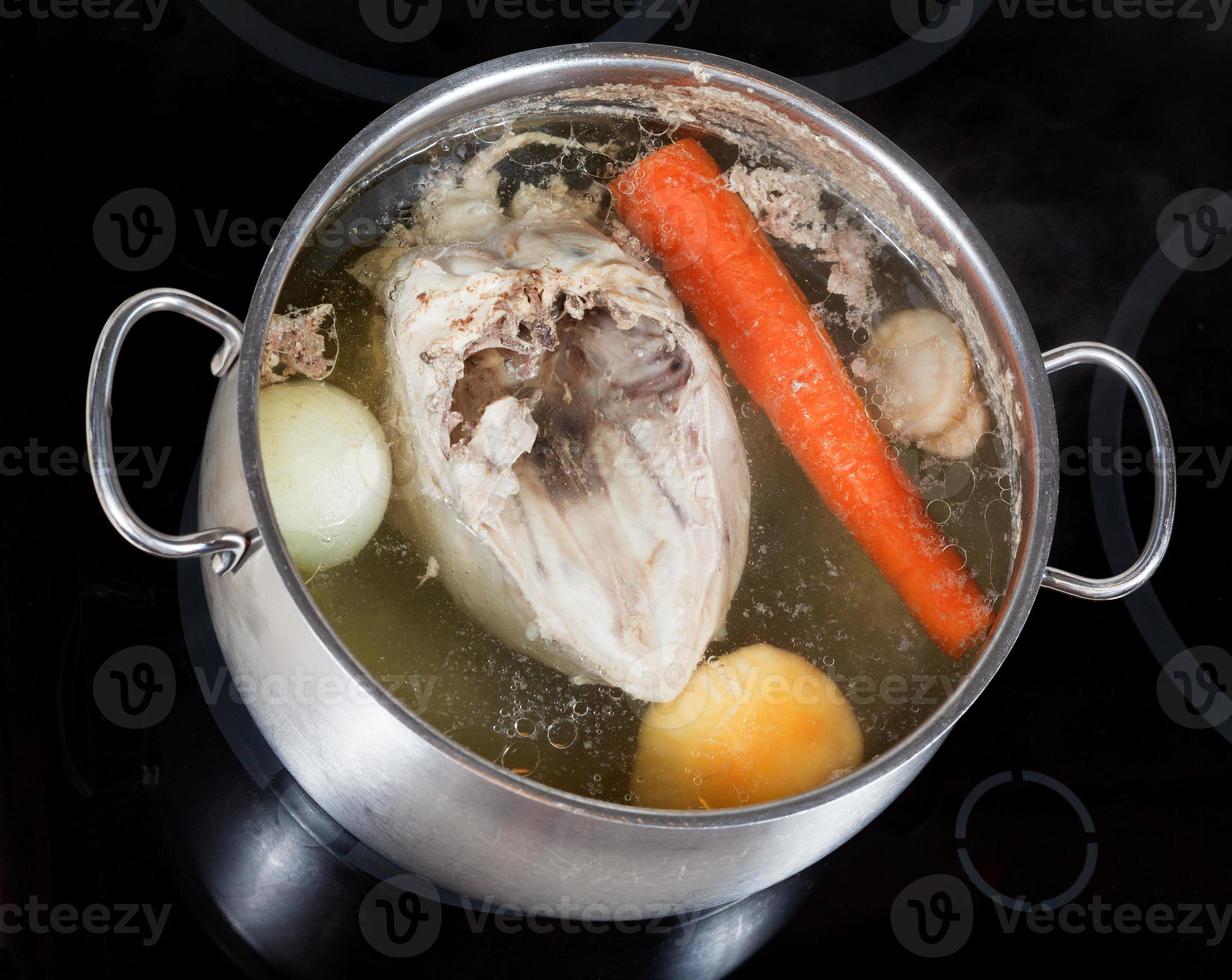 koken van kip bouillon met kruiderij groenten foto