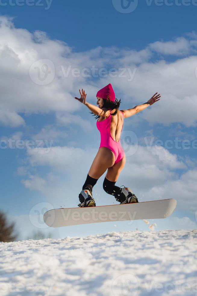 jong mooi vrouw jumping Aan een snowboard foto