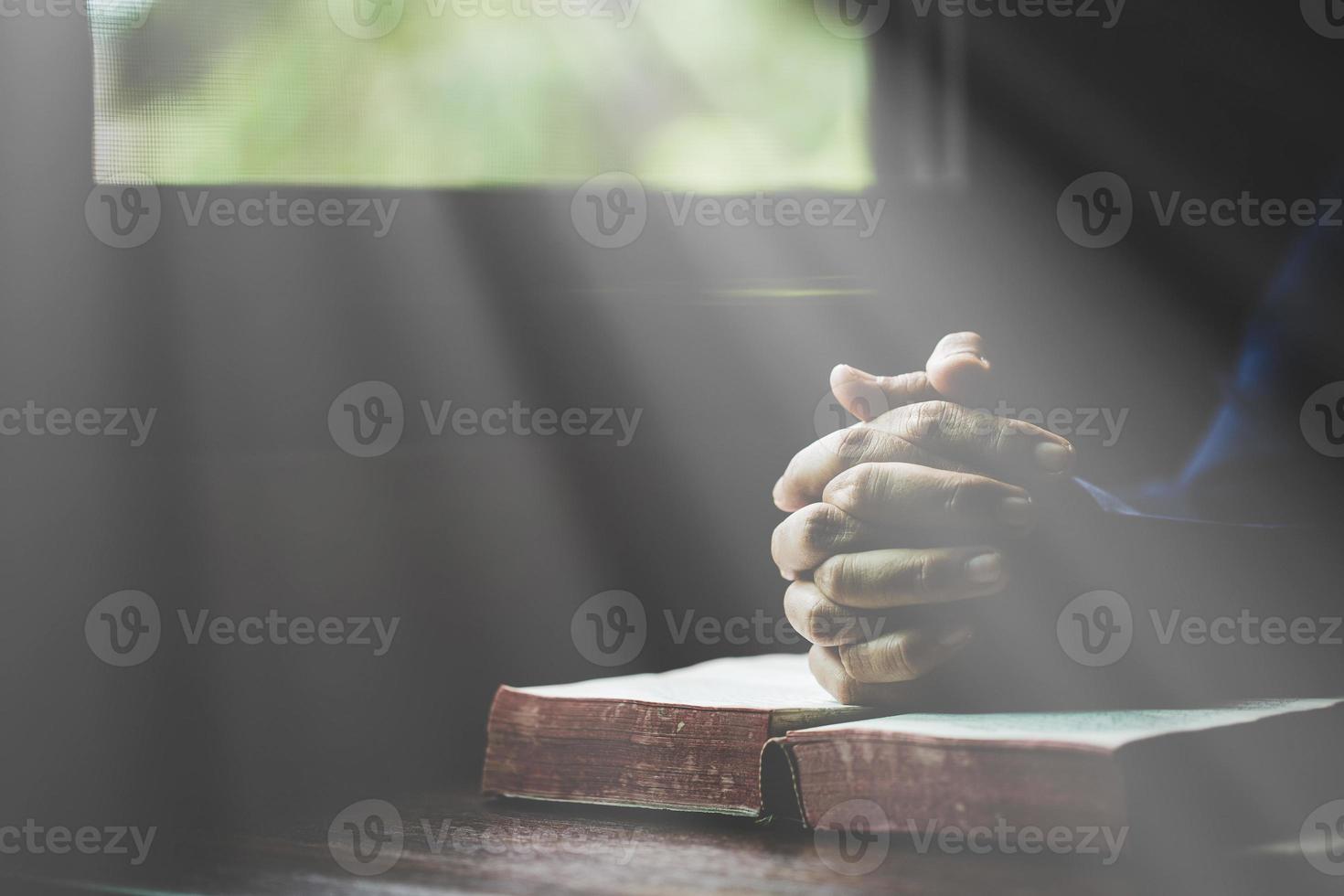 hand- gevouwen in gebed naar god Aan heilig Bijbel boek in kerk concept voor vertrouwen, geestelijkheid en geloof, vrouw persoon bidden Aan heilig Bijbel in ochtend. christen Katholiek vrouw hand- met Bijbel aanbidding. foto