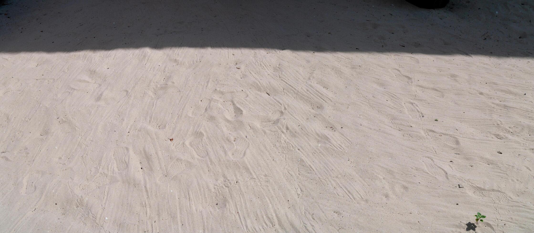 de zand verdieping met de schaduw van de zon Aan top met de voetafdrukken van mensen Aan de zand, de beeld van panorama visie foto