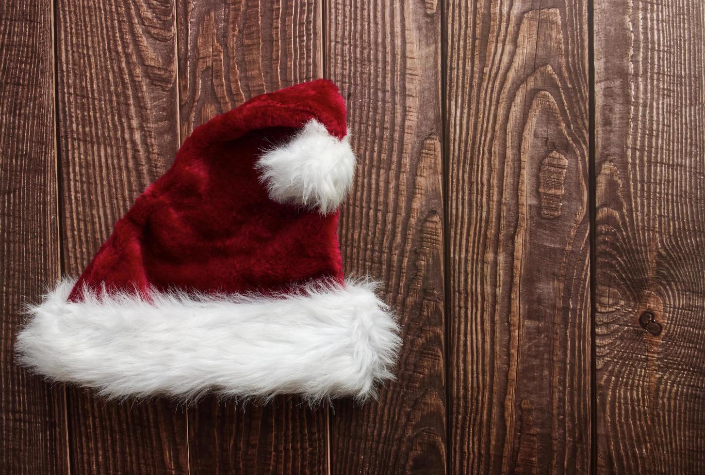 rood de kerstman claus hoed geïsoleerd Aan houten achtergrond. ruimte voor tekst. vlak leggen. foto