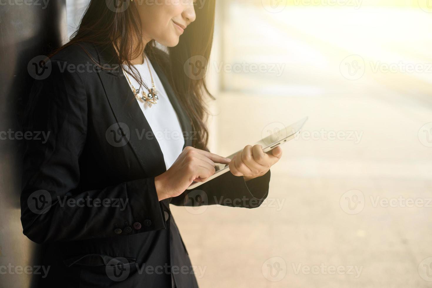 zakenvrouw in slim gewoontjes gebruik makend van digitaal tablet buitenshuis foto