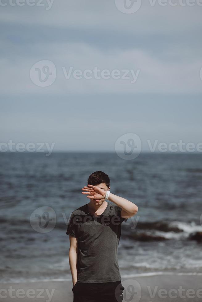knap Mens poseren Aan een achtergrond van zee foto