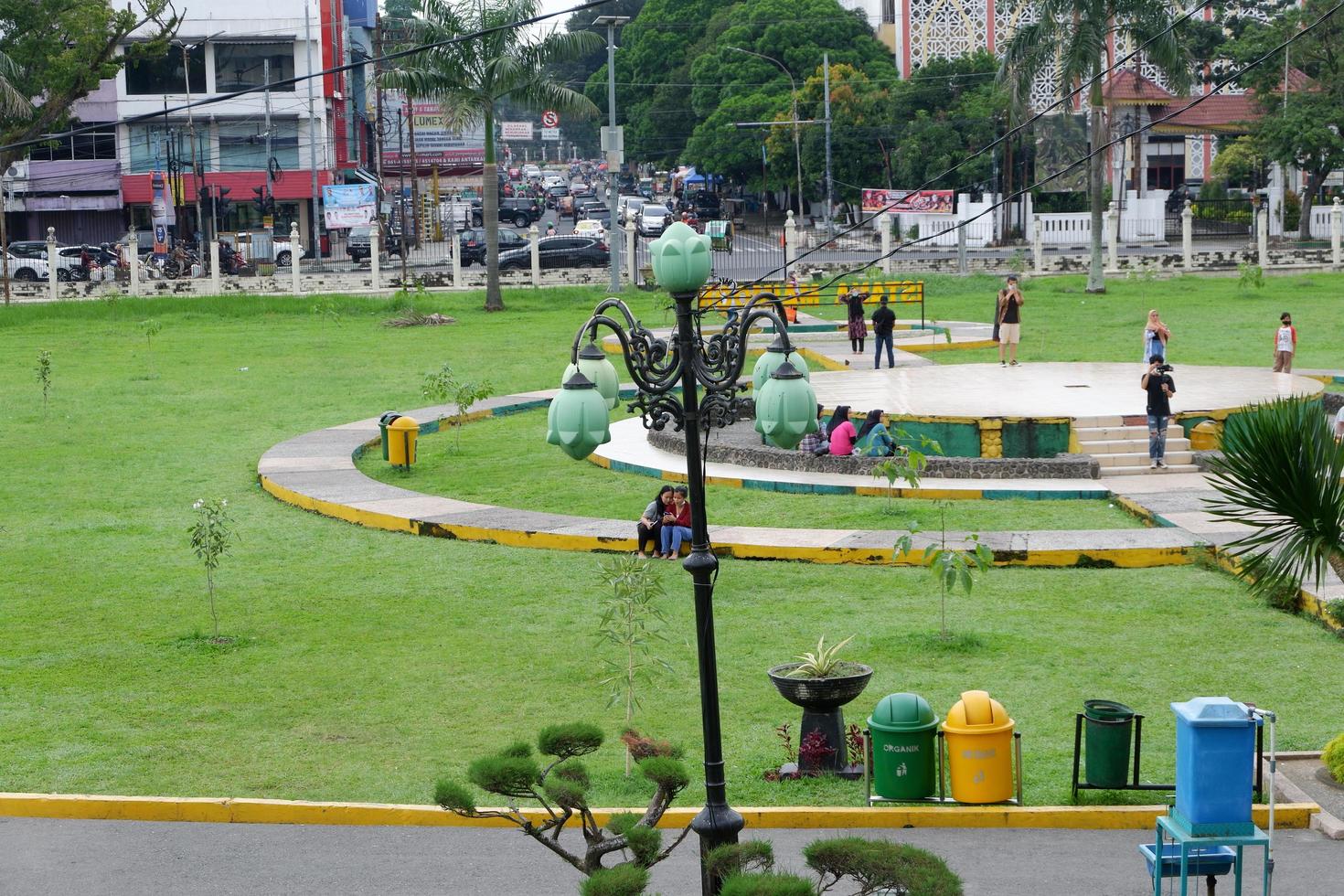 Medan, Indonesië - november 16, 2021, park visie Bij de centrum van een stad met een park lamp, en mensen aan het doen werkzaamheid, en een jogging bijhouden foto