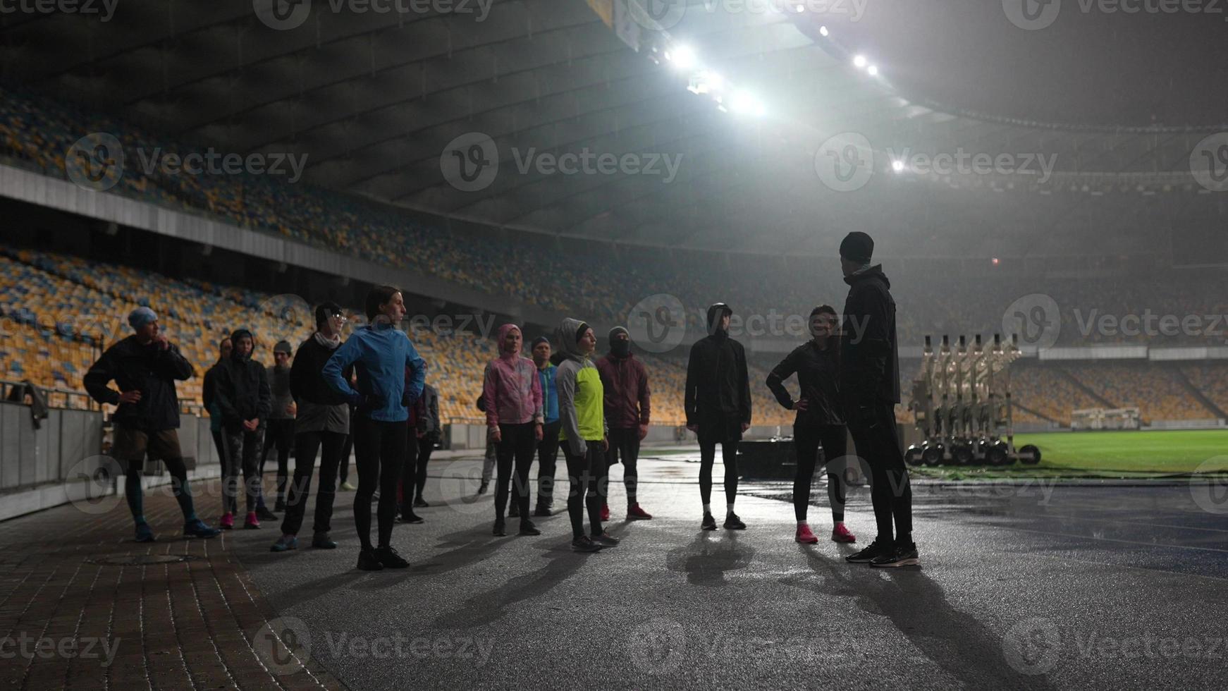 mensen Gaan in voor sport- Bij nacht stadion in regenachtig weer foto