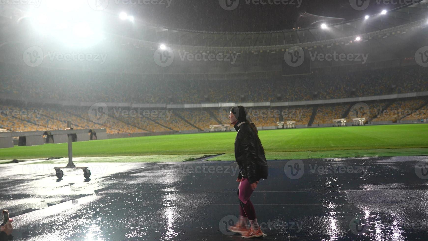 mensen Gaan in voor sport- Bij nacht stadion in regenachtig weer foto