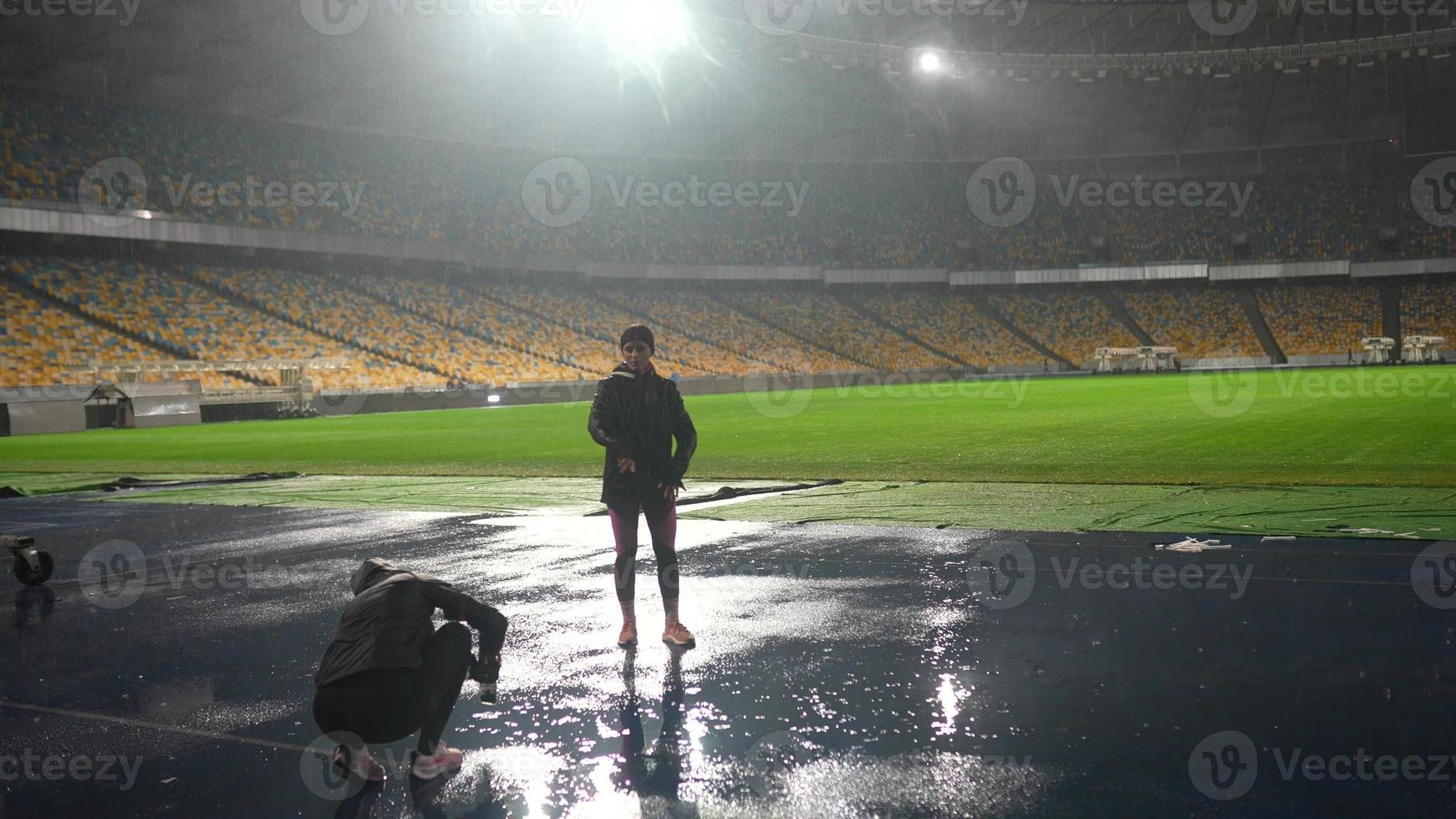 mensen Gaan in voor sport- Bij nacht stadion in regenachtig weer foto