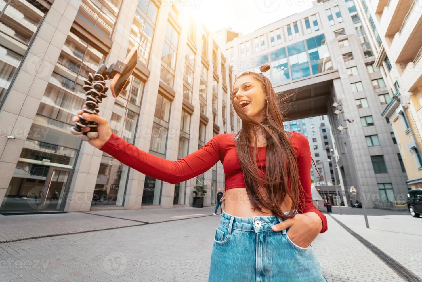jong vrouw blogger met smartphone streaming Aan de straat. foto