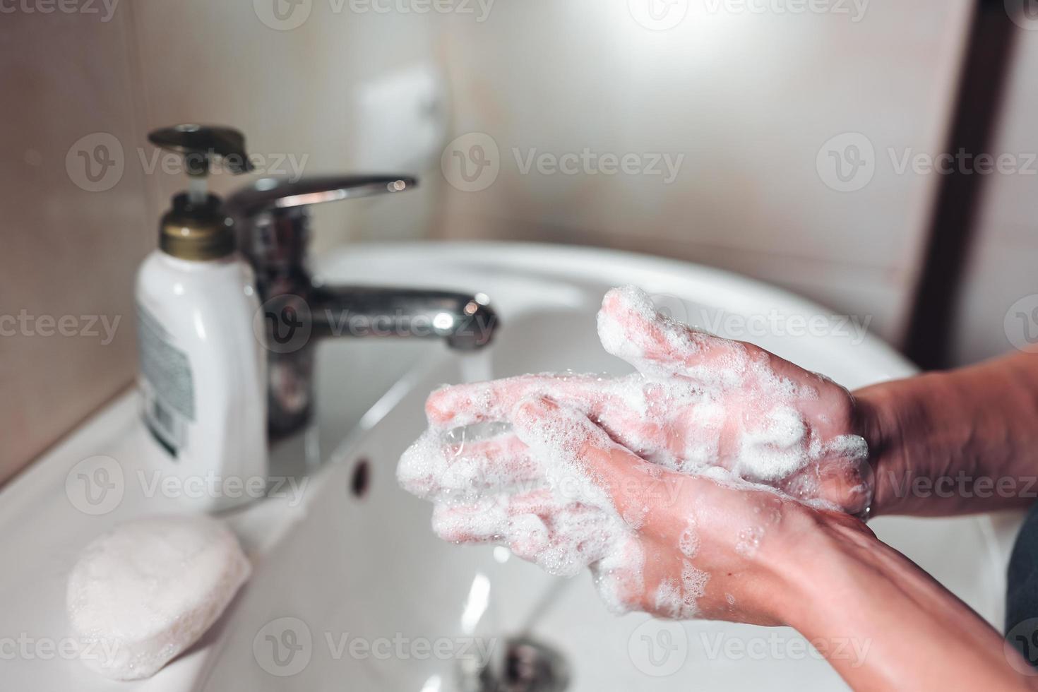 Mens het wassen handen naar beschermen tegen de coronavirus foto