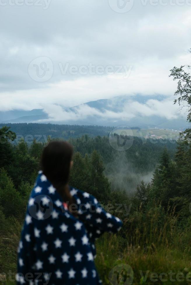 vrouw staand Aan top van een heuvel, tegen de achtergrond van een vallei foto