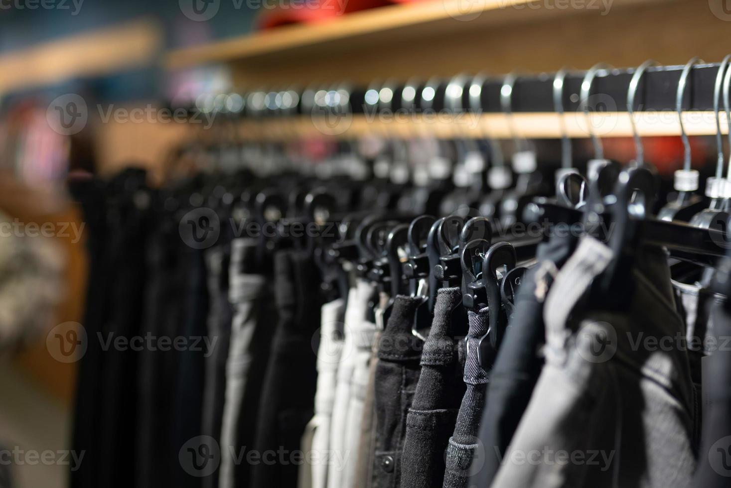 elegant kleren Aan een hanger in een op te slaan. nieuw verzameling van jassen. foto