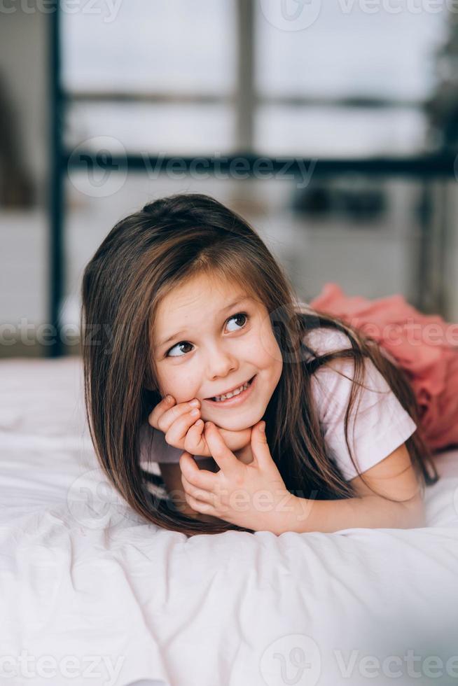 weinig meisje aan het liegen in de bed op zoek weg. foto