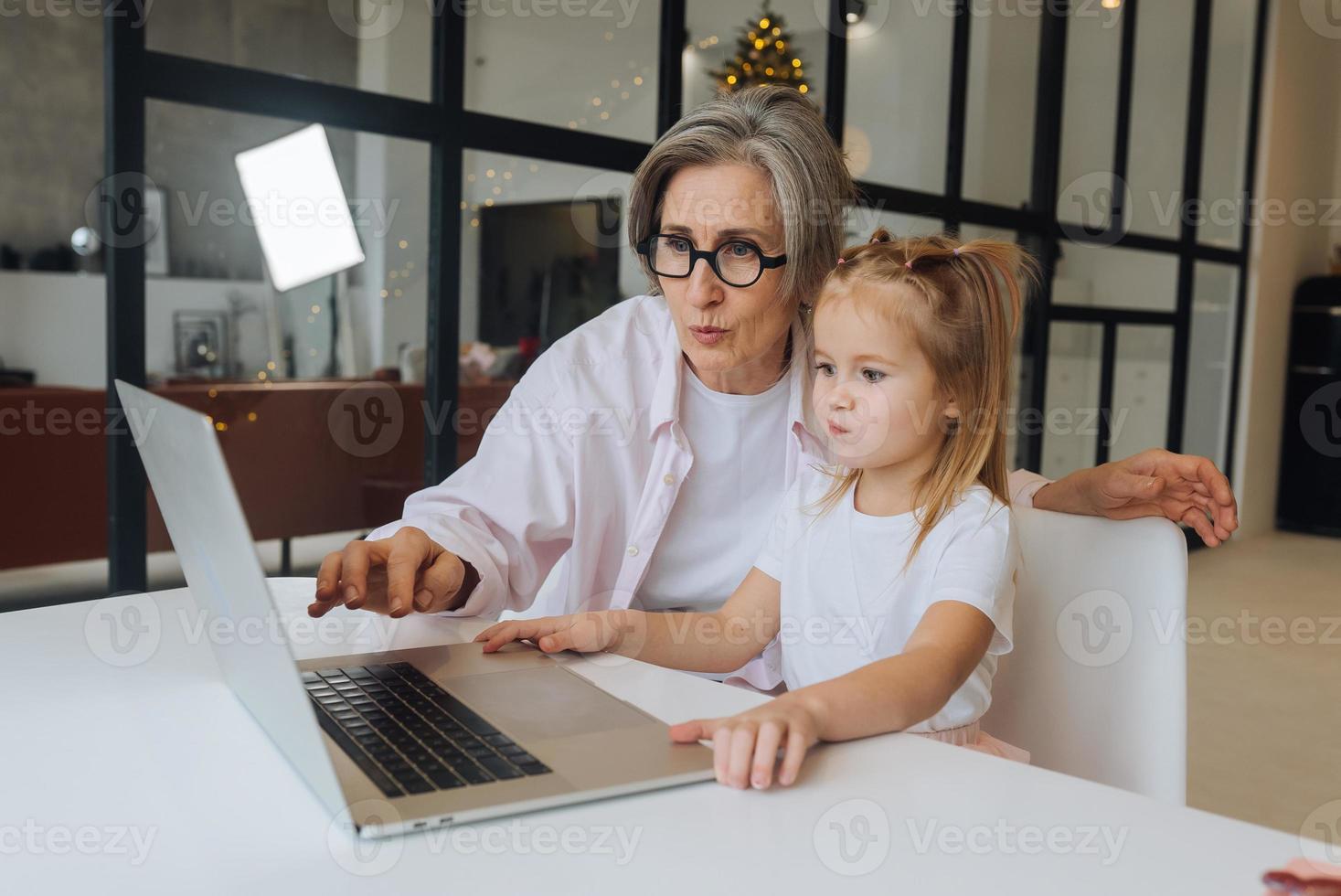 kind en oma op zoek Bij de camera met laptop foto