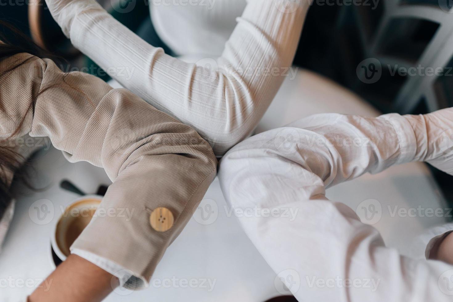 collega's in beschermend maskers geven hoog vijf met ellebogen. foto