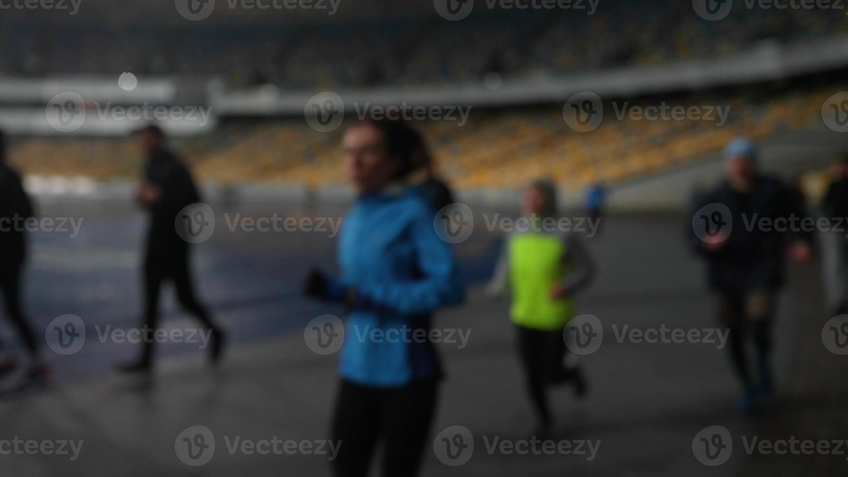 mensen Gaan in voor sport- Bij nacht stadion in regenachtig weer foto