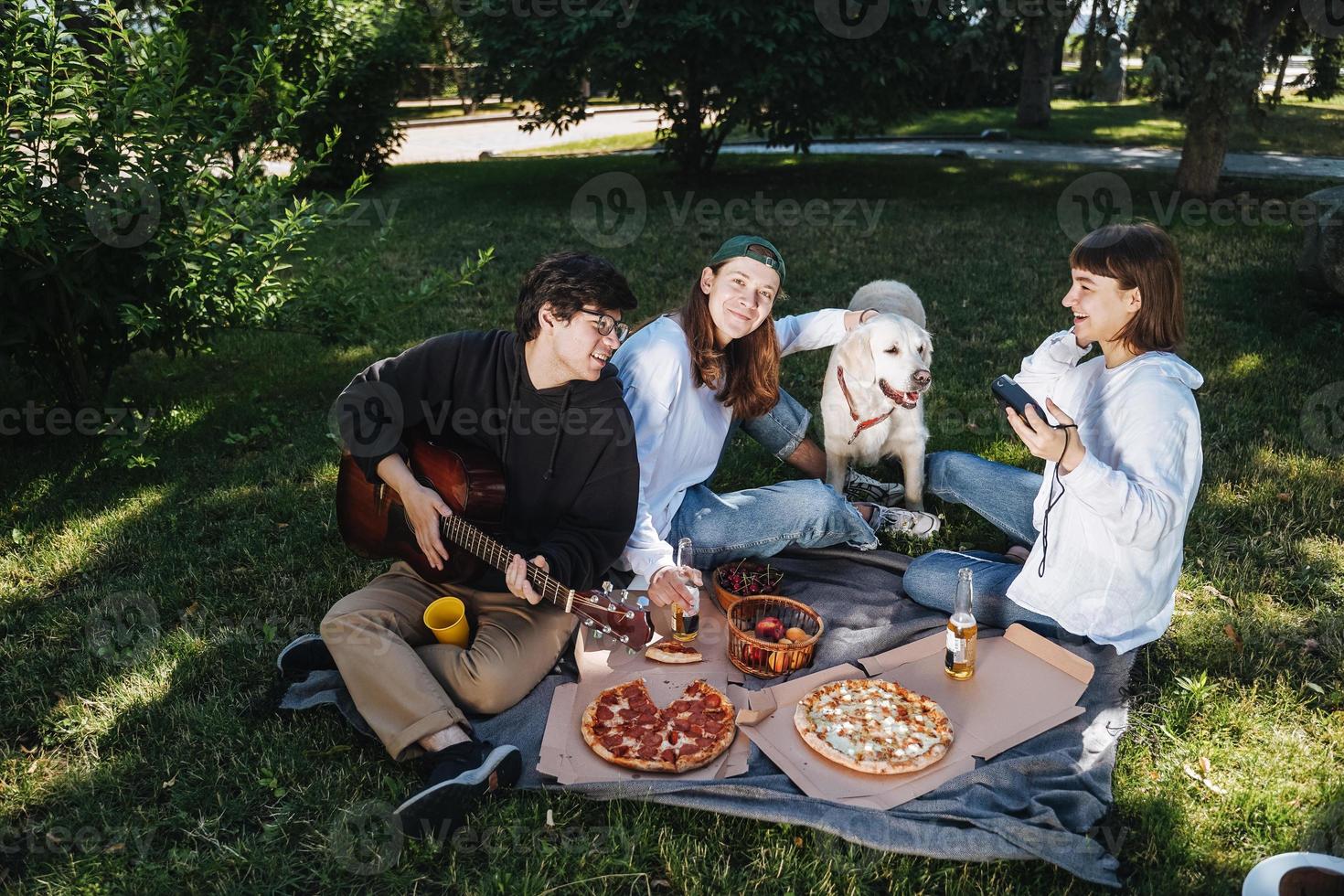 bedrijf van mooi jong mensen en hond hebben een buitenshuis lunch. foto