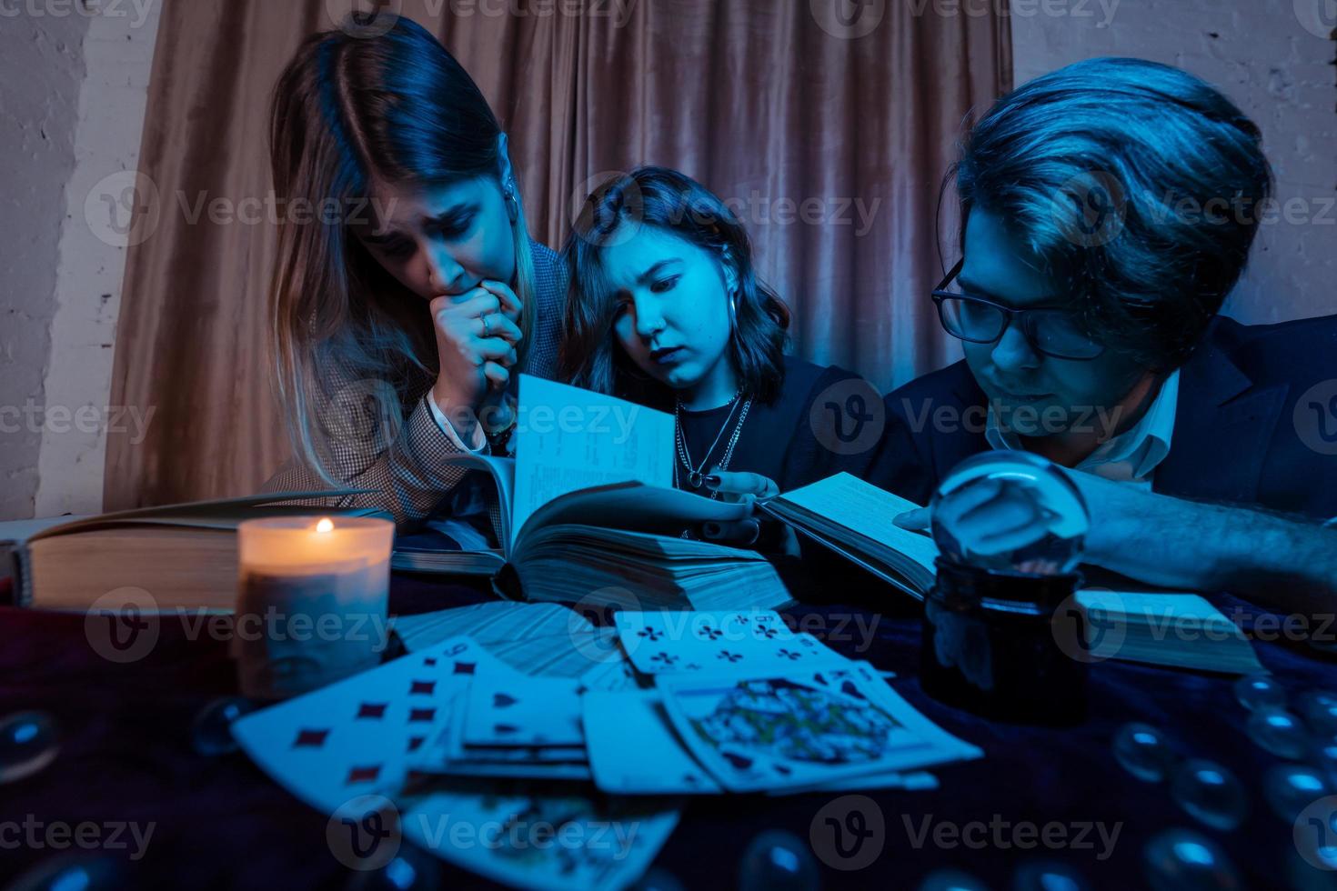 twee Dames en een vent zijn lezing een mysterieus boeken, dichtbij visie foto