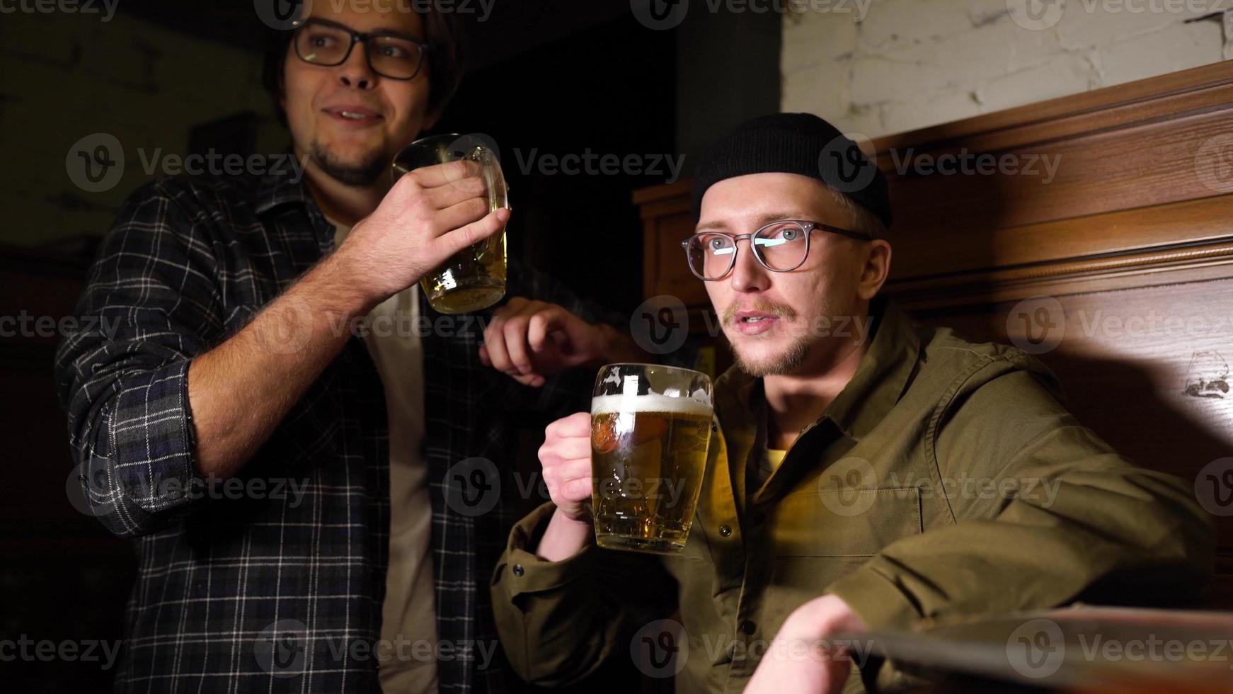 jong vrienden hebben pret samen drinken bier in een kroeg. foto