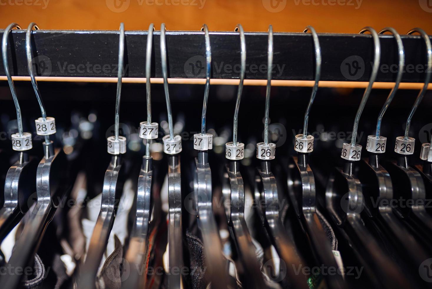 elegant kleren Aan een hanger in een op te slaan. nieuw verzameling van jassen. foto