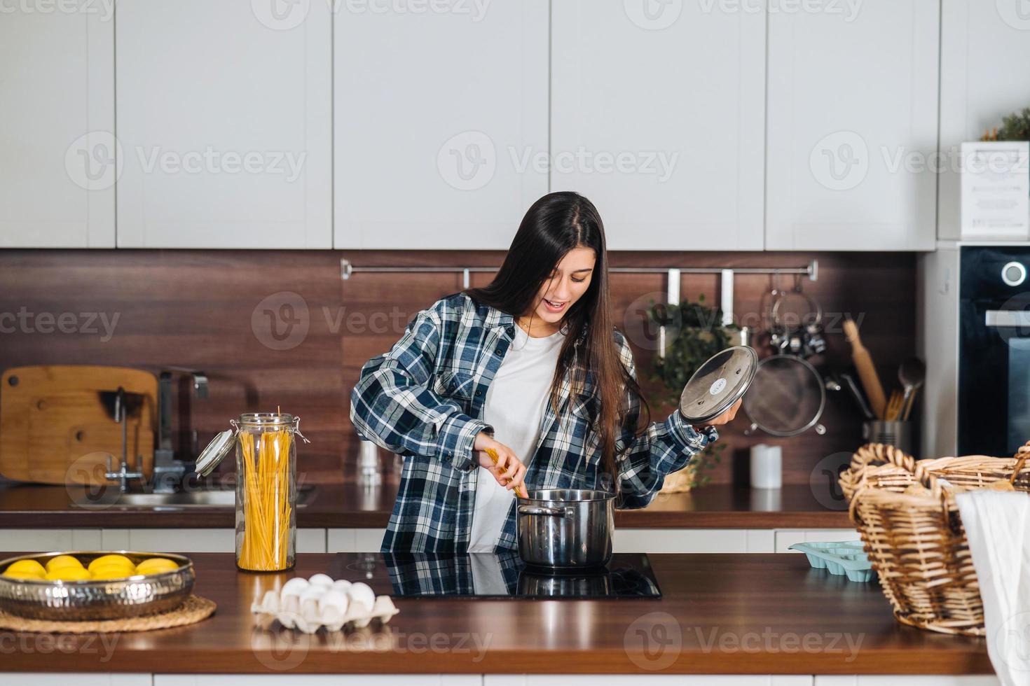 jong vrouw in modern keuken, voorbereidingen treffen spaghetti foto