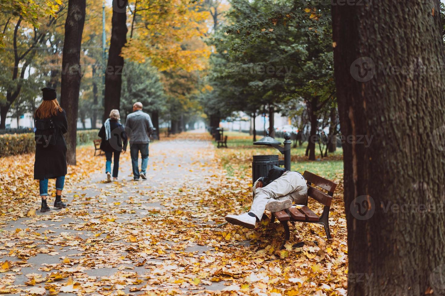 dakloos slapen Aan de banken in de herfst park foto