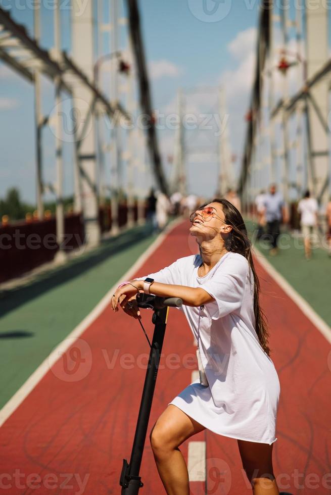 jong mooi vrouw en een elektrisch scooter, ecologisch vervoer foto