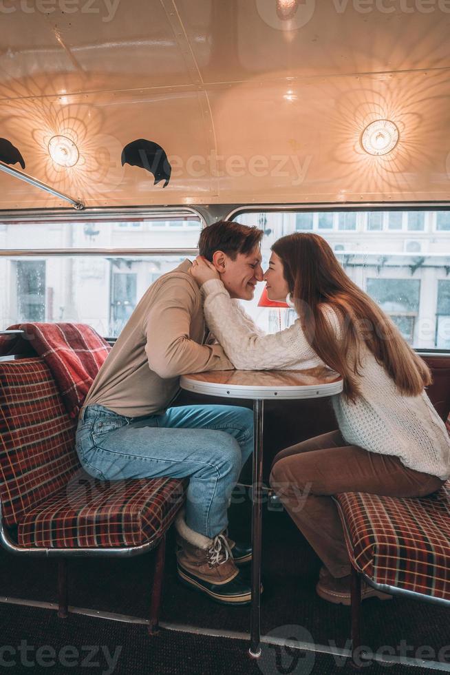 liefhebbend jong paar in winter tijd zittend in een cafe foto