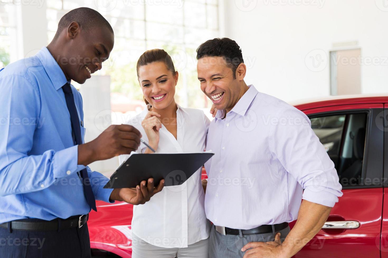 Afrikaanse autodealer verkoopcontract uit te leggen aan paar foto