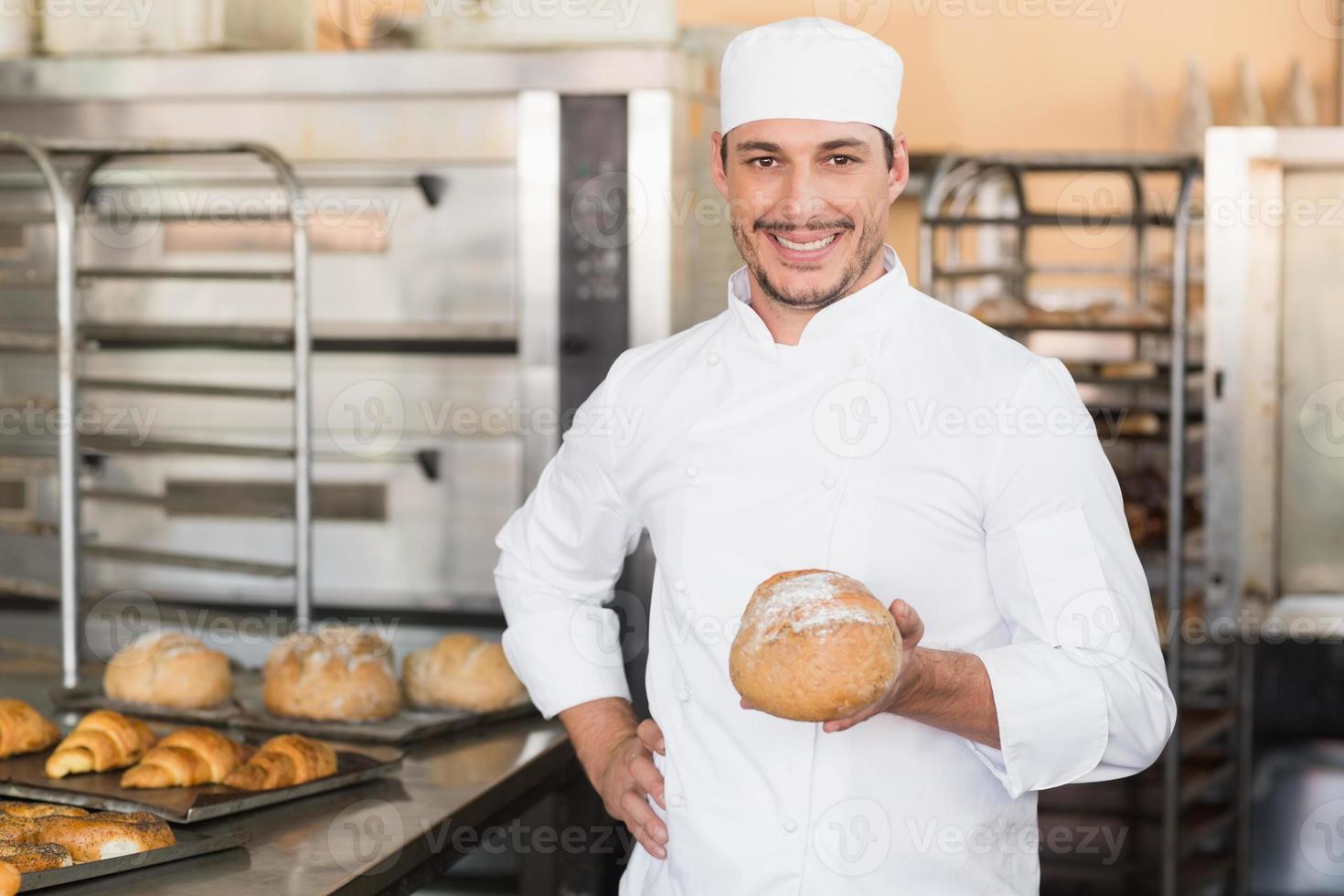 bakker met een versgebakken brood foto