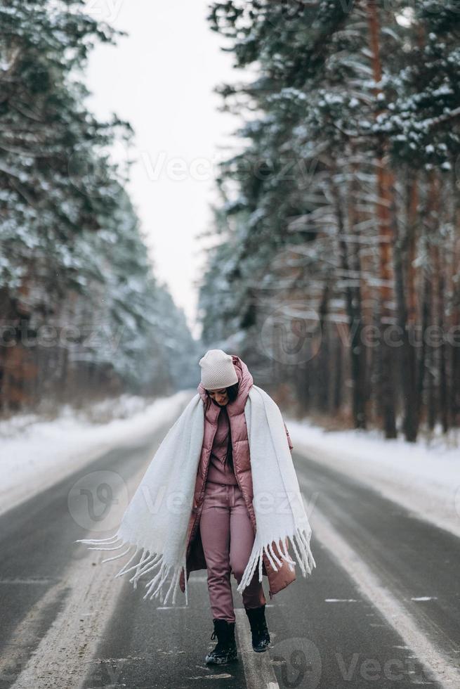 portret van een mooi Kaukasisch vrouw Aan een weg door besneeuwd Woud foto