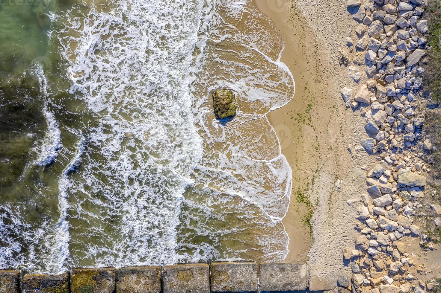 antenne top visie van dar naar de zeekust met schoonheid golven en steenachtig strand. zee achtergrond. foto