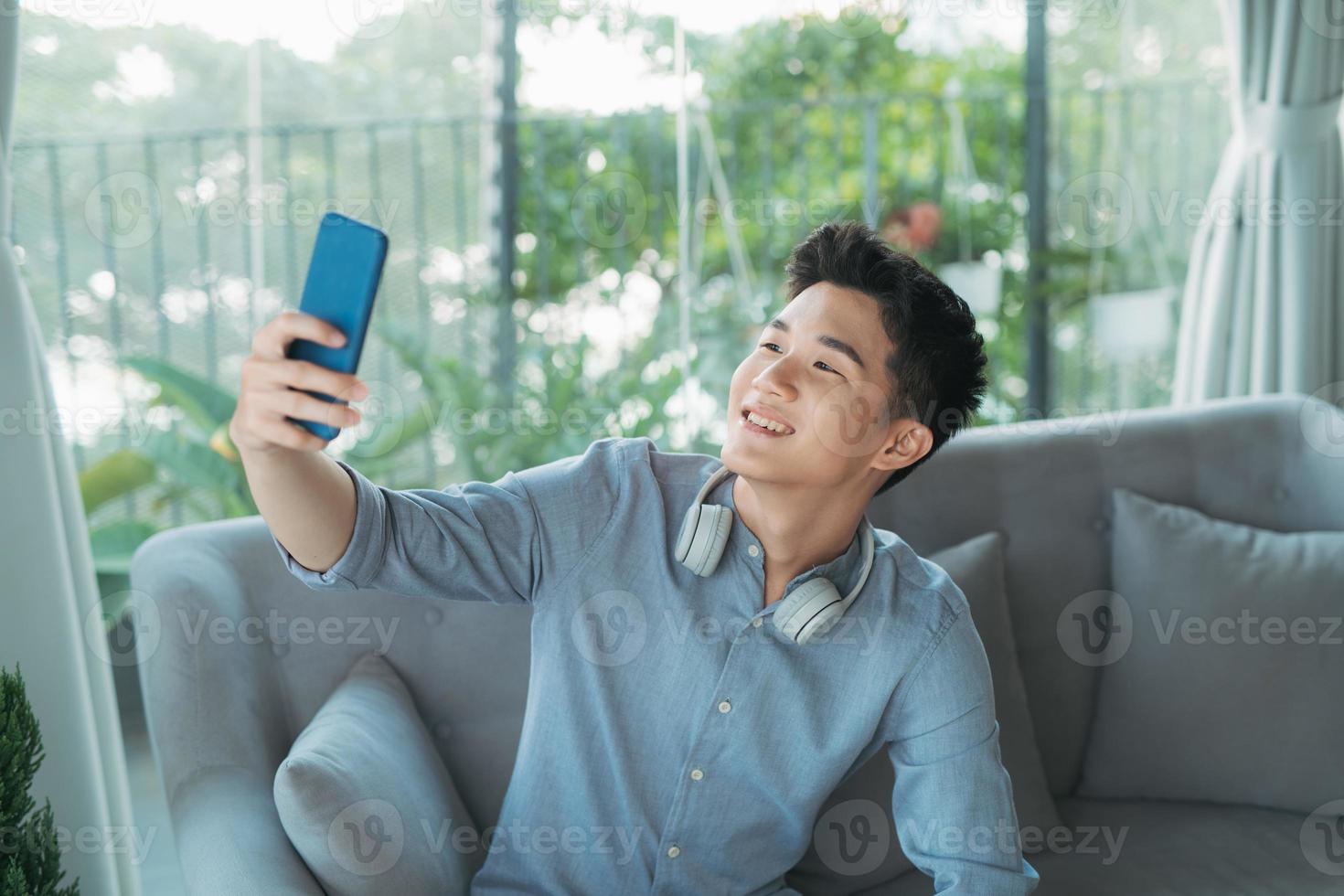jong knap Mens nemen selfie vervelend draadloze hoofdtelefoons luisteren muziek- foto