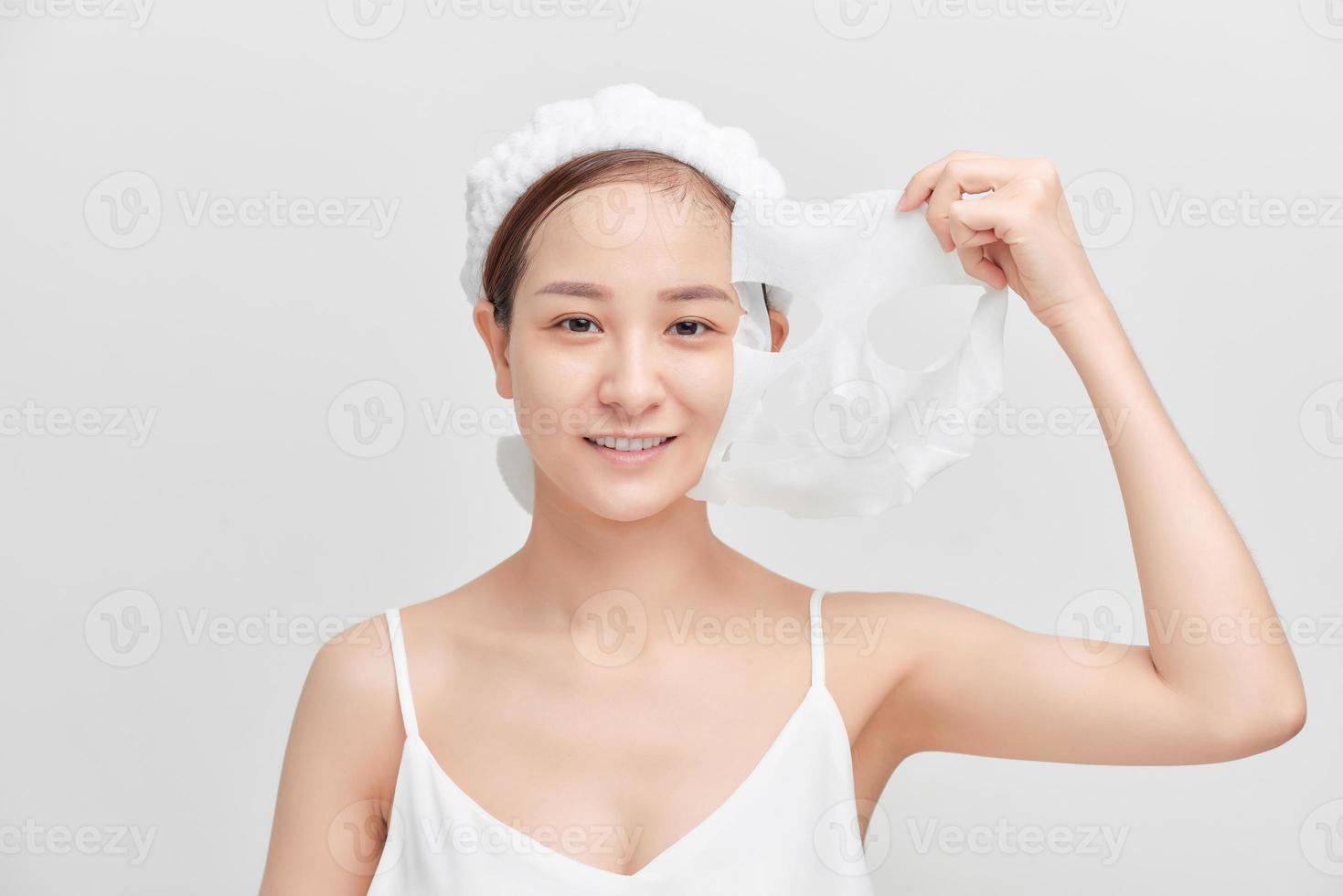 jong Aziatisch vrouw Verwijderen haar kunstmatig masker. foto
