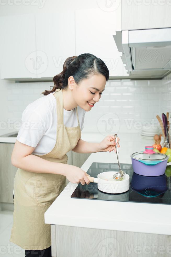 jong vrouw Koken in de keuken. gezond voedsel. dieet concept. gezond levensstijl. Koken Bij huis. bereiden voedsel foto