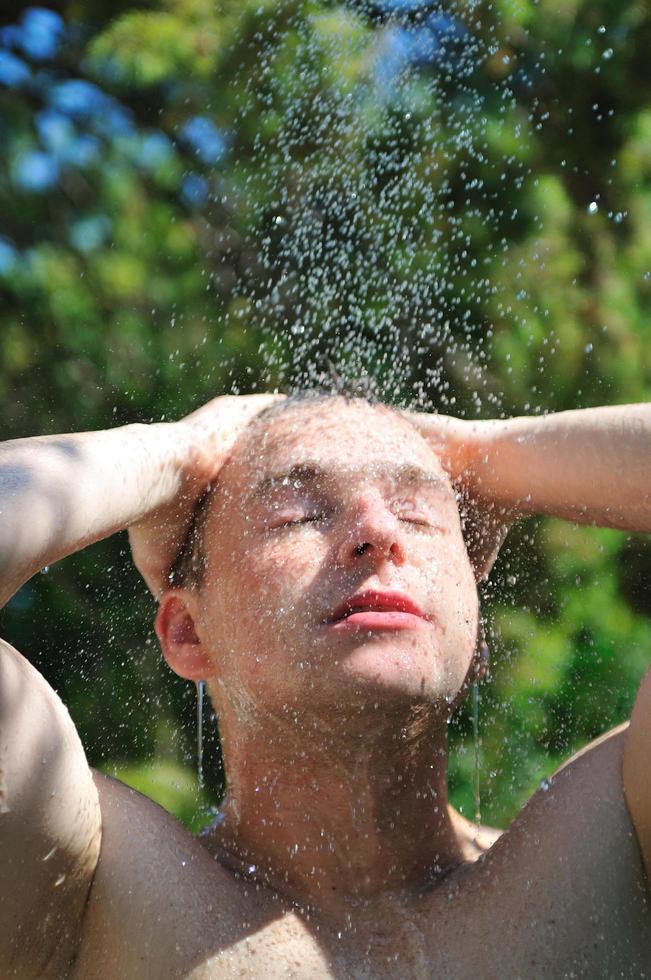 jong Mens ontspannende onder douche foto