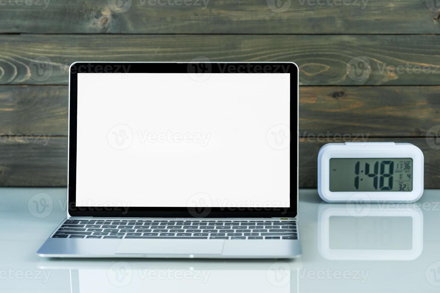 laptop mockup en alarm klok met hout achtergrond Aan de werk tafel foto