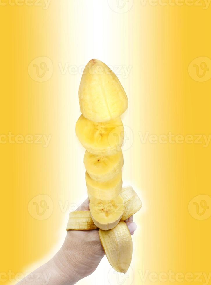 banaan geschild was draaide zich om naar stukken in zijn hand- Aan een wit geel achtergrond. foto