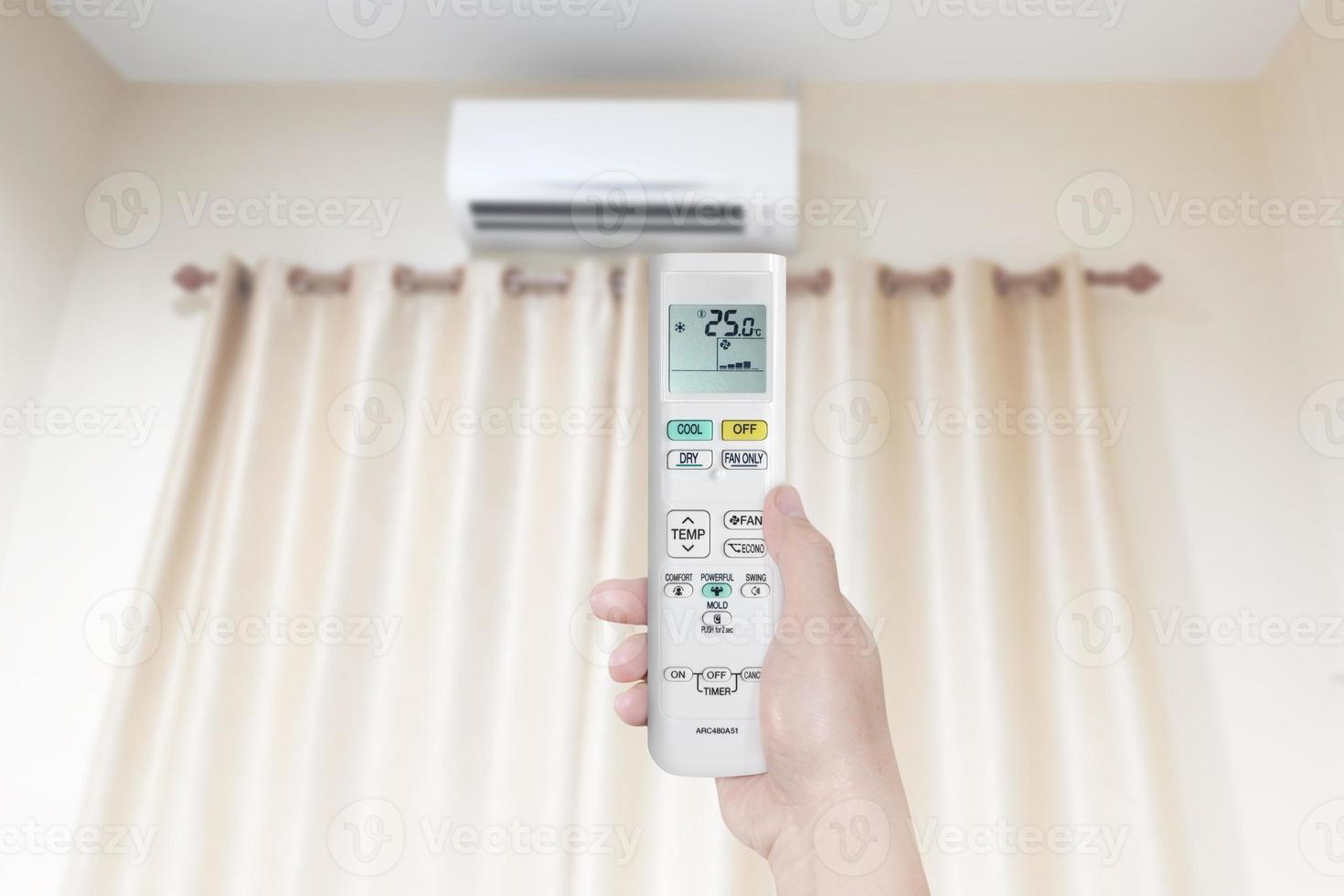 vrouw Holding lucht conditioner afgelegen controle met lucht conditioner in slaapkamer foto