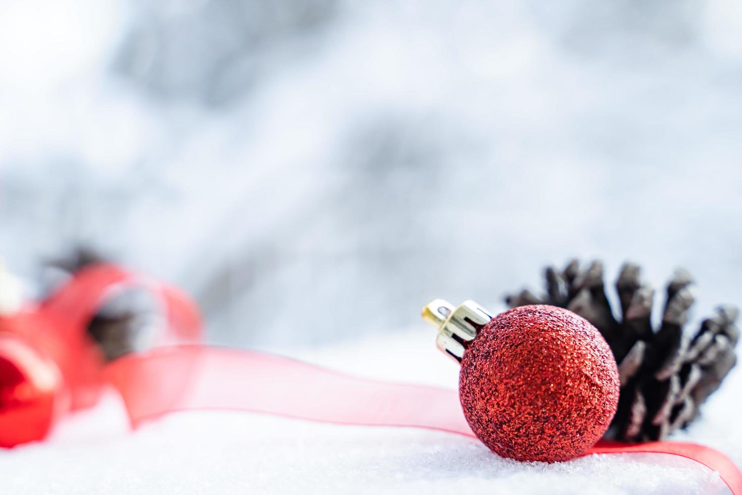 Kerstmis van winter - Kerstmis ballen met lint Aan sneeuw, winter vakantie concept. Kerstmis rood ballen, gouden ballen, pijnboom en sneeuwvlokken decoraties in sneeuw achtergrond foto