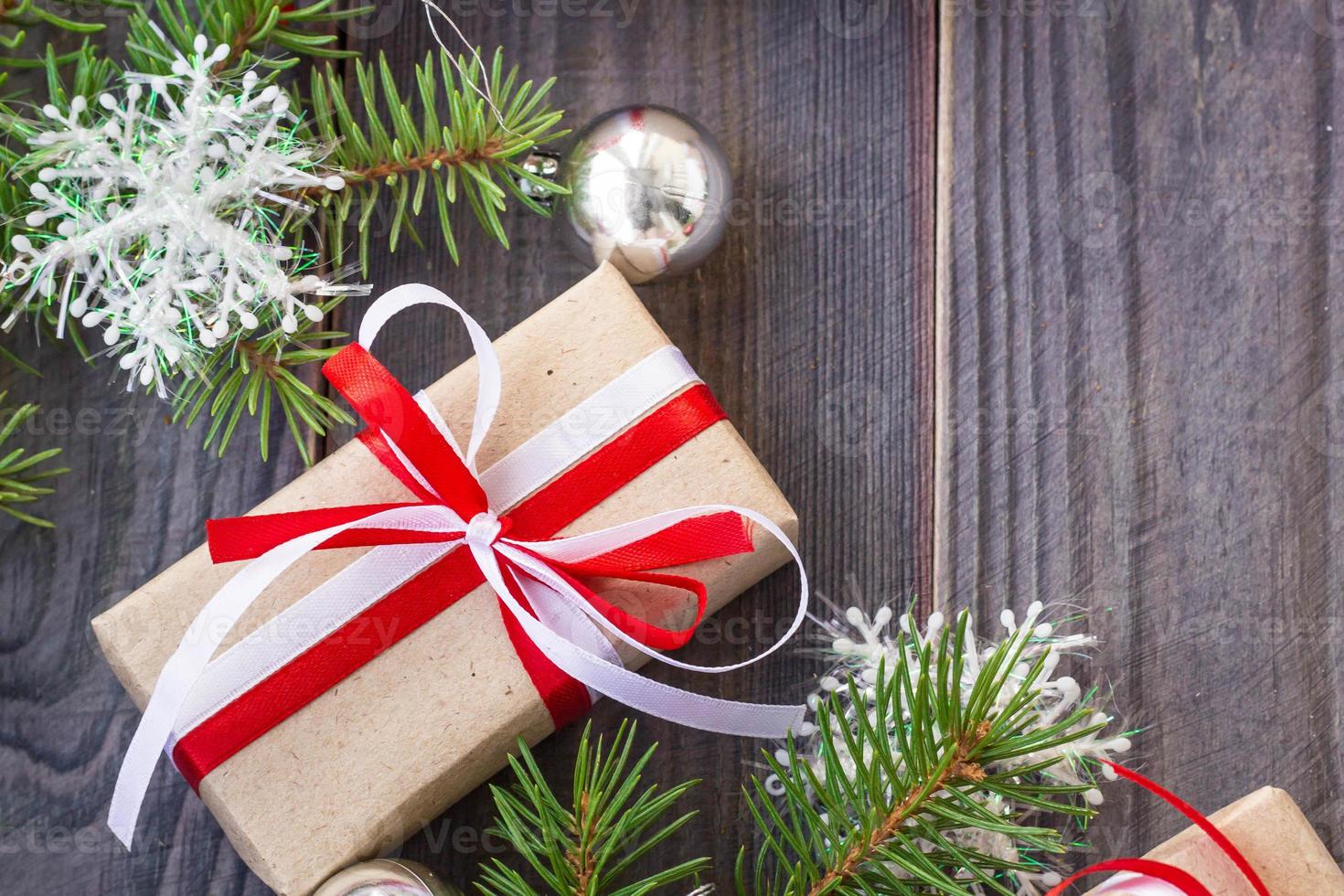 Kerstmis achtergrond met Spar boom en decoraties en geschenk dozen Aan houten bord foto