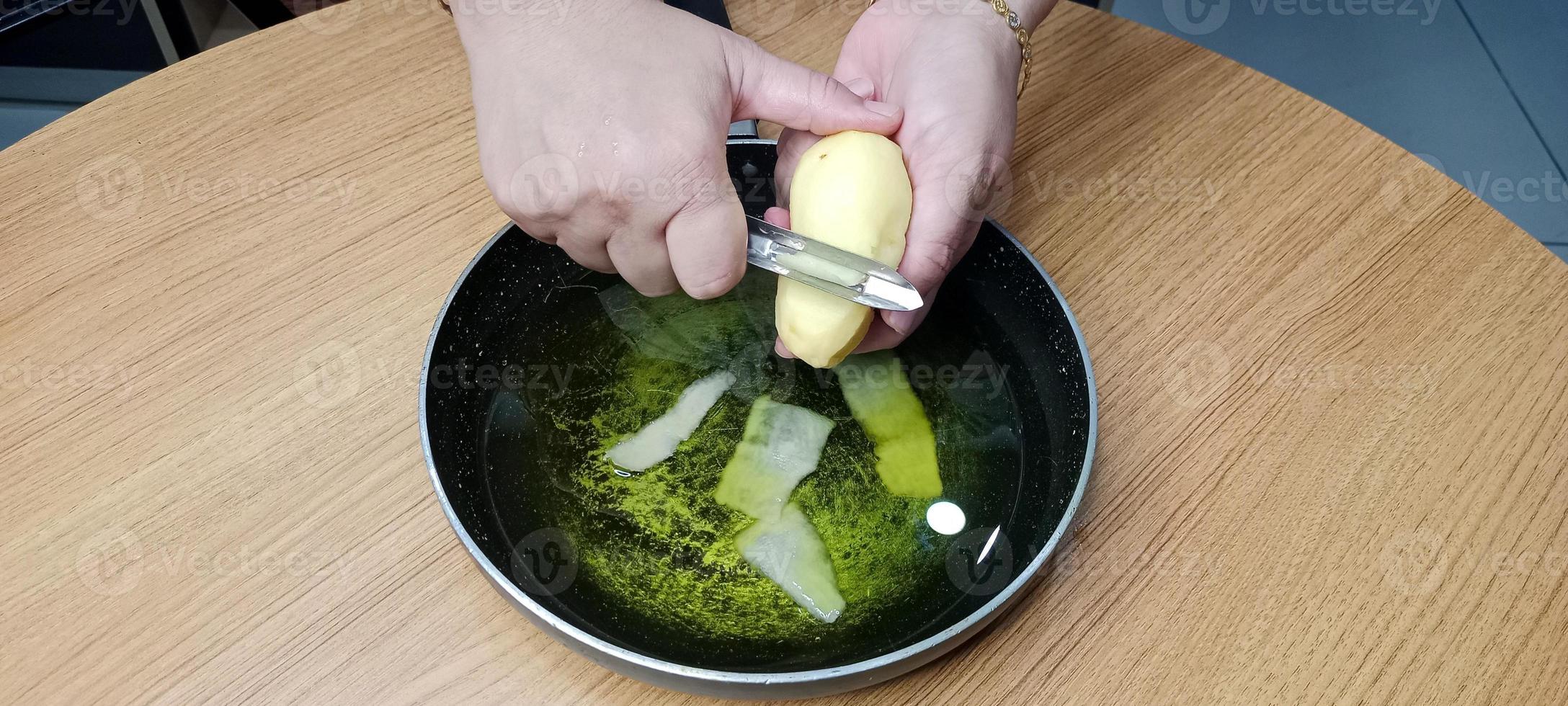 aardappel schillen in olie voor maken werkwijze van aardappel chips, aal chips foto