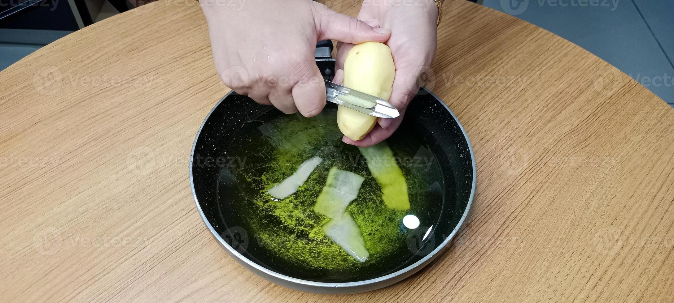 aardappel schillen in olie voor maken werkwijze van aardappel chips, aal chips foto
