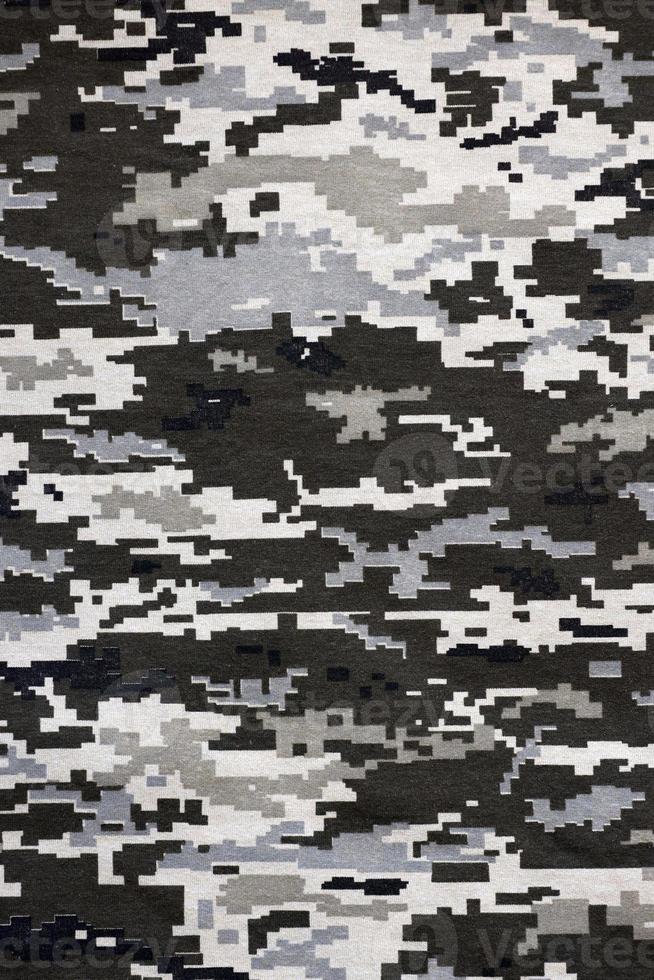 kleding stof met structuur van oekraïens leger korrelig camouflage. kleding met camo patroon in grijs, bruin en groen pixel vormen. officieel uniform van oekraïens soldaten foto